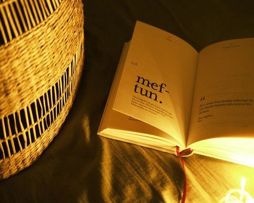 An open book illuminated by a warm bedside lamp
